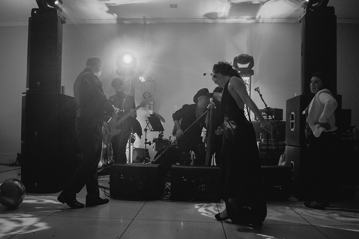 fotografia em preto e branco da formanda em medicina dançando alegremente durante o show de rock da sua recepção de formatura em medicina em Pelotas. Foto por Marco Moscarelli Fotografo.