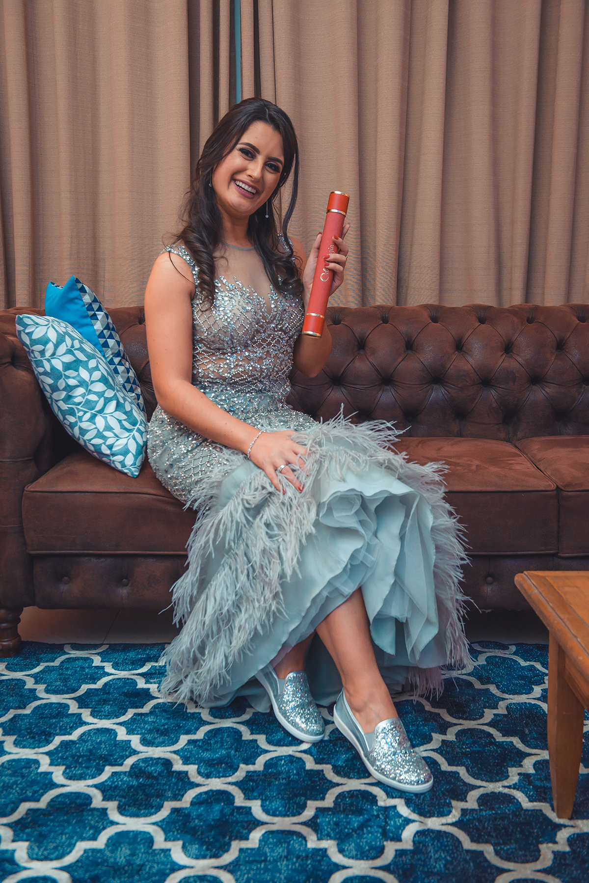 Foto linda da formanda segurando seu canudo de formatura e mostrando seu lindo sapato durante a sua recepção de formatura. Foto 