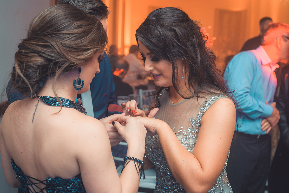 Fotografia expontanea da formanda mostrando seu anel de formatura durante a sua recepção de formatura em odontologia em Pelotas. Foto por Marco Moscarelli Fotografo.
