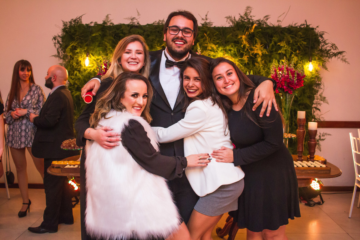 Formando sendo abraçado por suas amigas e convidadas durante a sua recepção de formatura. Foto por Marco Moscarelli Fotografo.