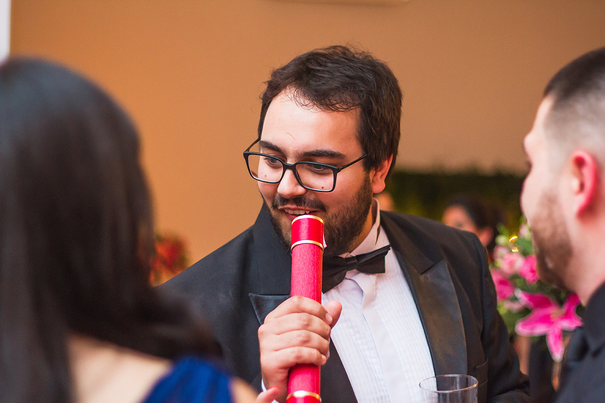 Formando em foto descontraída co seu canudo de formatura em odontologia em Pelotas. Foto por Marco Moscarelli Fotografo.