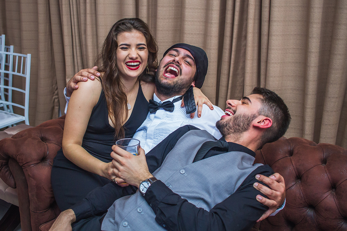Formando em foto descontraída com seus convidados durante a sua recepção de  formatura em odontologia em Pelotas. Foto por Marco Moscarelli Fotografo.