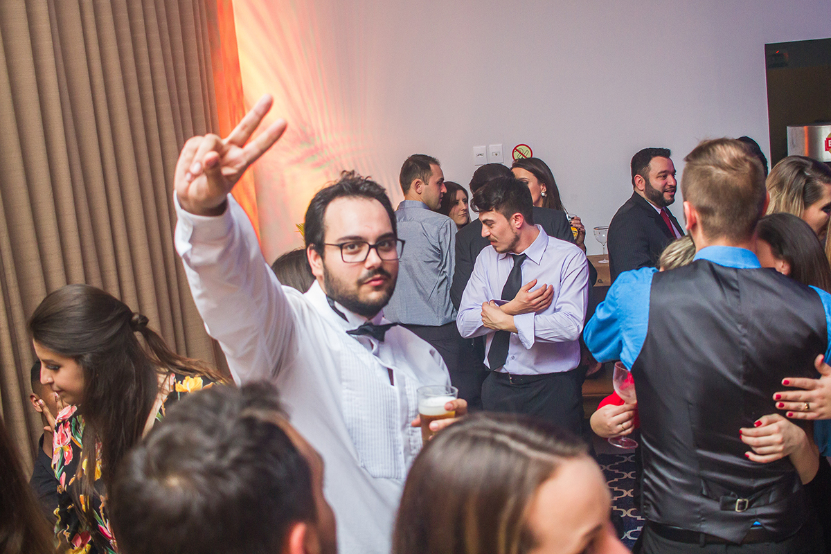 Formando em foto descontraída durante a sua recepção de  formatura em odontologia em Pelotas. Foto por Marco Moscarelli Fotografo.