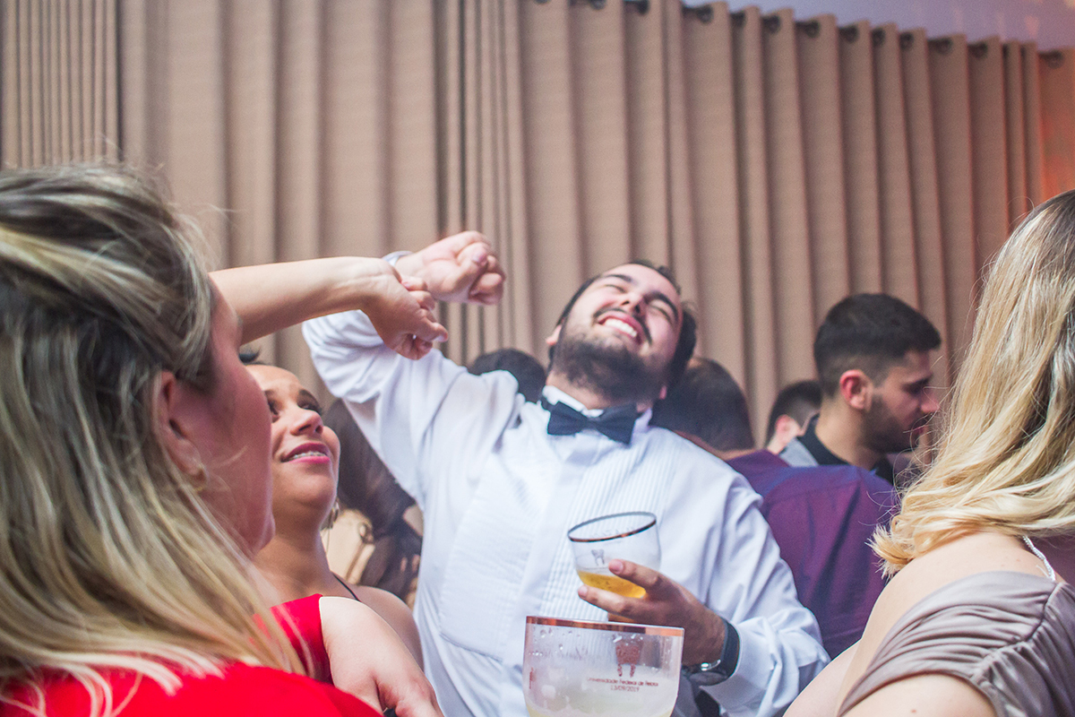 Formando em foto descontraída durante a sua recepção de  formatura em odontologia em Pelotas. Foto por Marco Moscarelli Fotografo.
