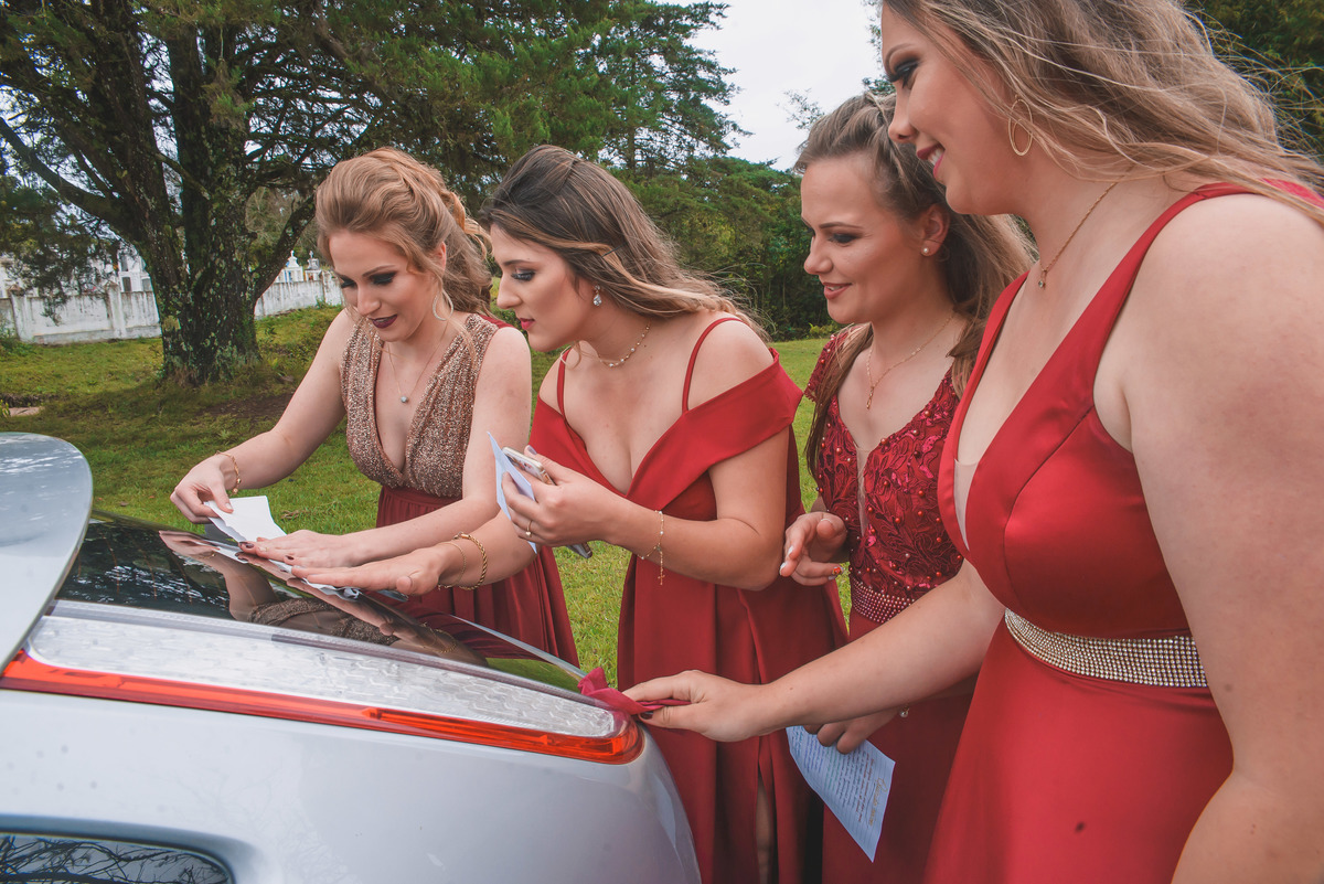 Madrinhas da Noiva decorando o carro dos noivos após o casamento.  Foto por Marco Moscarelli Fotografo Pelotas.