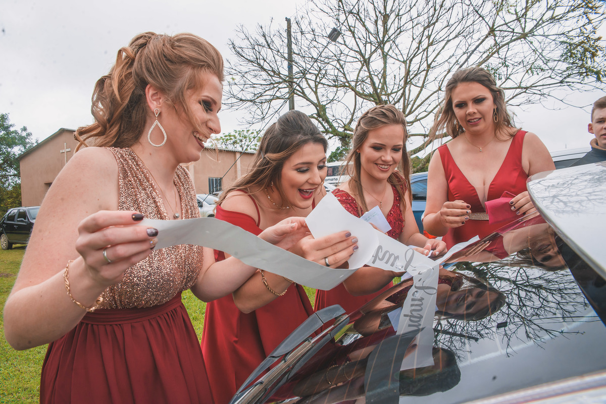 Madrinhas da Noiva decorando o carro dos noivos após o casamento.  Foto por Marco Moscarelli Fotografo Pelotas.