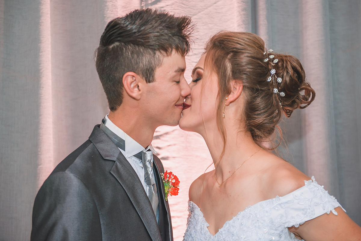 Fotografia de um lindo beijo dos noivos durante a recepção após o casamento. Foto por Marco Moscarelli Fotografo Pelotas.