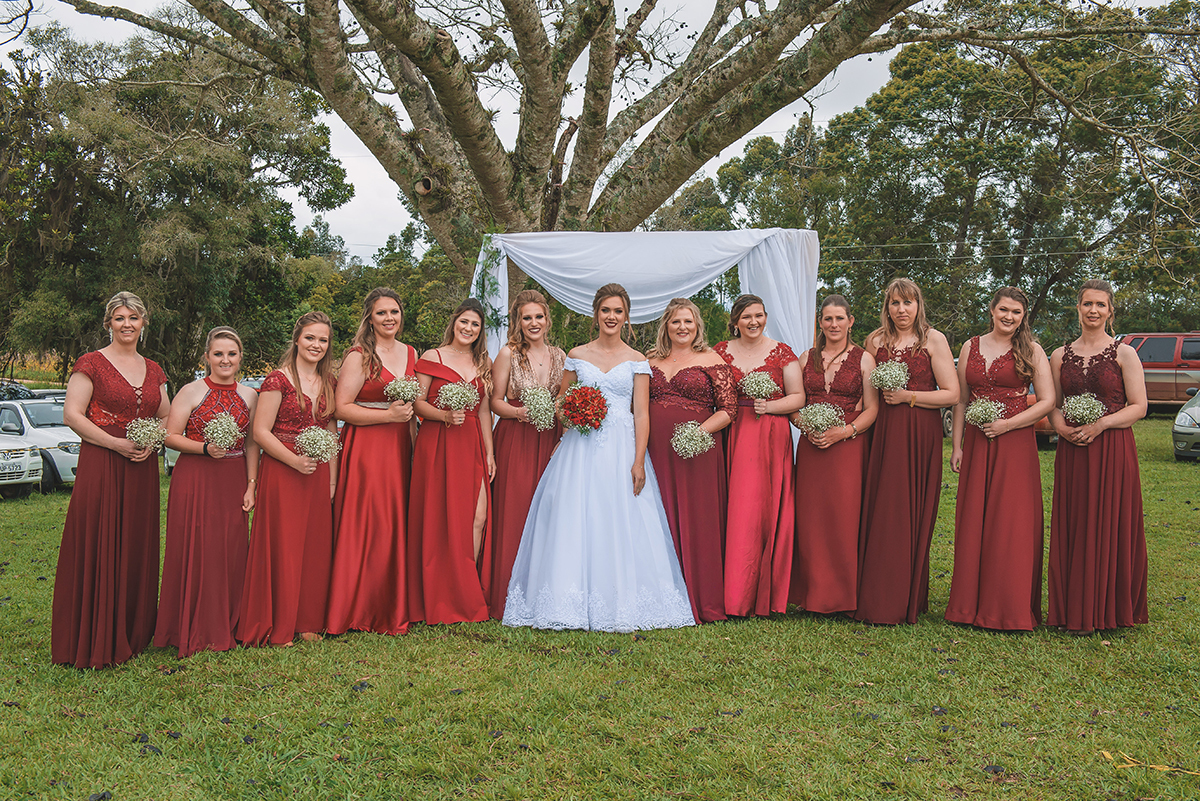 Noiva e suas  madrinhas de casamento posando para foto sob uma linda figueira. Foto por Marco Moscarelli Fotografo Pelotas.