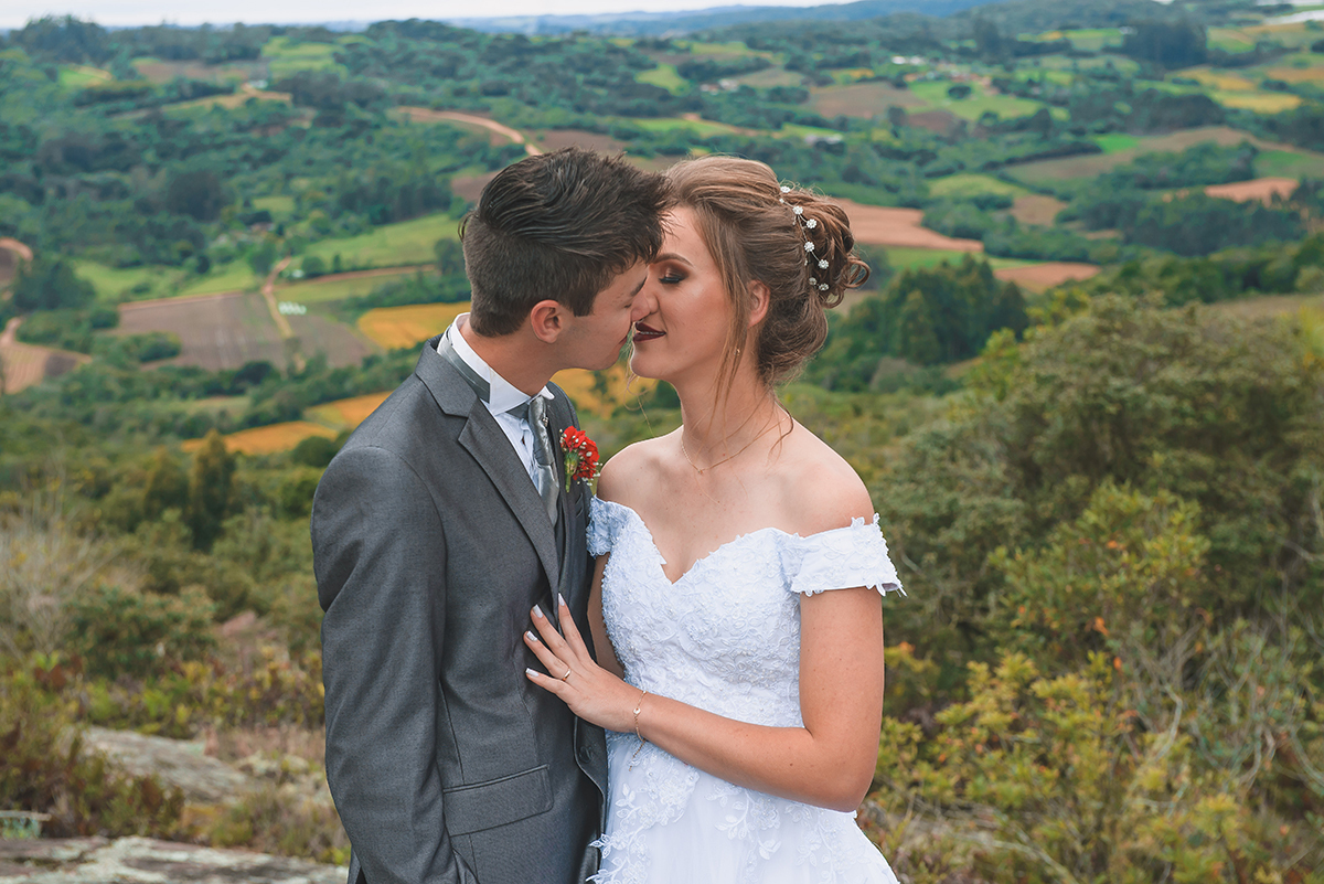 Noivos posando para foto de ensaio pós casamento com um lindo vale da colonia de pelotas ao fundo.  Foto por Marco Moscarelli Fotografo Pelotas.