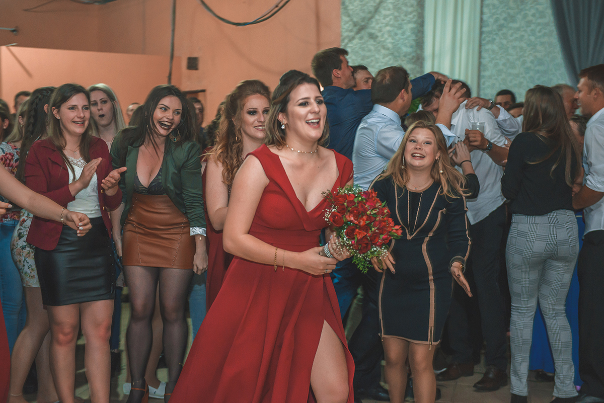 Foto da madrinha correndo após após  pegar o buque. Foto por Marco Moscarelli Fotografo Pelotas.