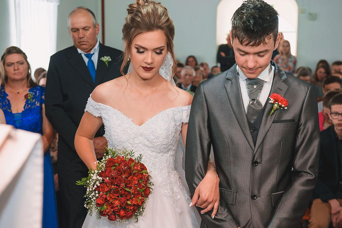Noivos orando com a cabeça baixa durante a cerimônia de casamento. Foto por Marco Moscarelli Fotografo Pelotas.