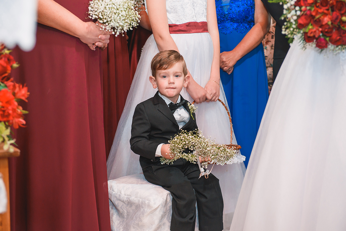 Foto descontraida do pagem sentado em um banco durante a cerimonia de casamento. Foto por Marco Moscarelli Fotografo Pelotas.