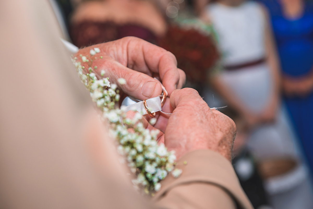 Foto em detalhe do momento da troca de alianças dos noivos durante o casamento. Foto por Marco Moscarelli Fotografo Pelotas.