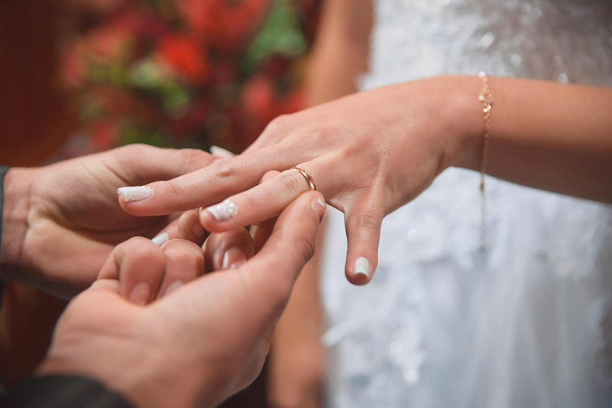 Foto em detalhe do momento da troca de alianças dos noivos durante o casamento. Foto por Marco Moscarelli Fotografo Pelotas.
