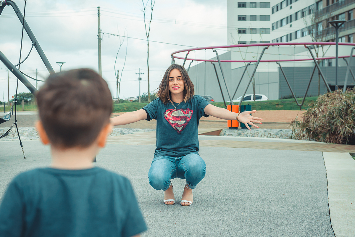 Mãe esperando o filho com os braços abertos durante ensaio fotográfico de família. Foto por Marco Moscarelli Fotografo Pelotas.