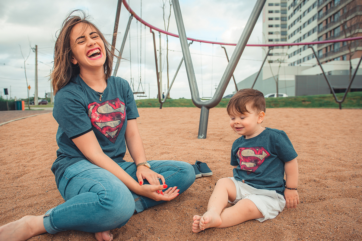 Lindo sorriso de Mãe e filho brincando com areia  durante ensaio fotográfico de família. Foto por Marco Moscarelli Fotografo Pelotas.