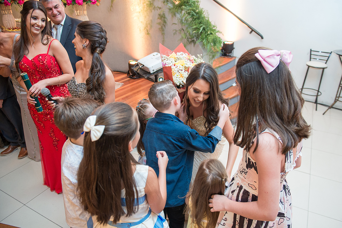 Crianças abraçando a formanda em sua formatura de medicina. Foto por Marco Moscarelli Fotografo Pelotas.