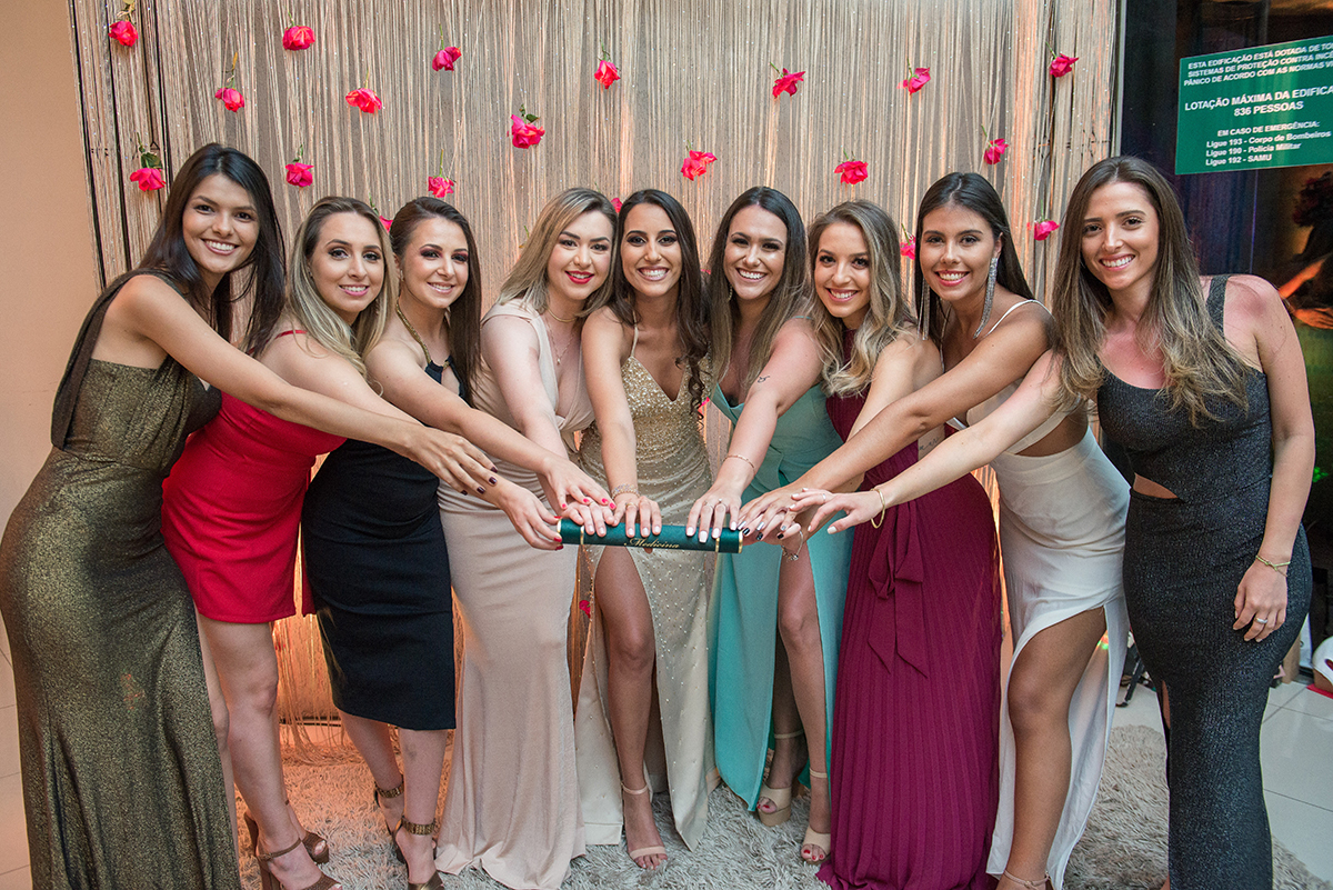 Amigas da formanda posando para foto todas segurando o canudo de formatura em medicina. Foto por Marco Moscarelli Fotografo Pelotas.