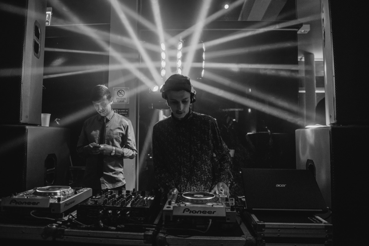 Fotografia em Preto e Branco do DJ da formatura com luzes ao fundo. Foto por Marco Moscarelli Fotografo Pelotas.
