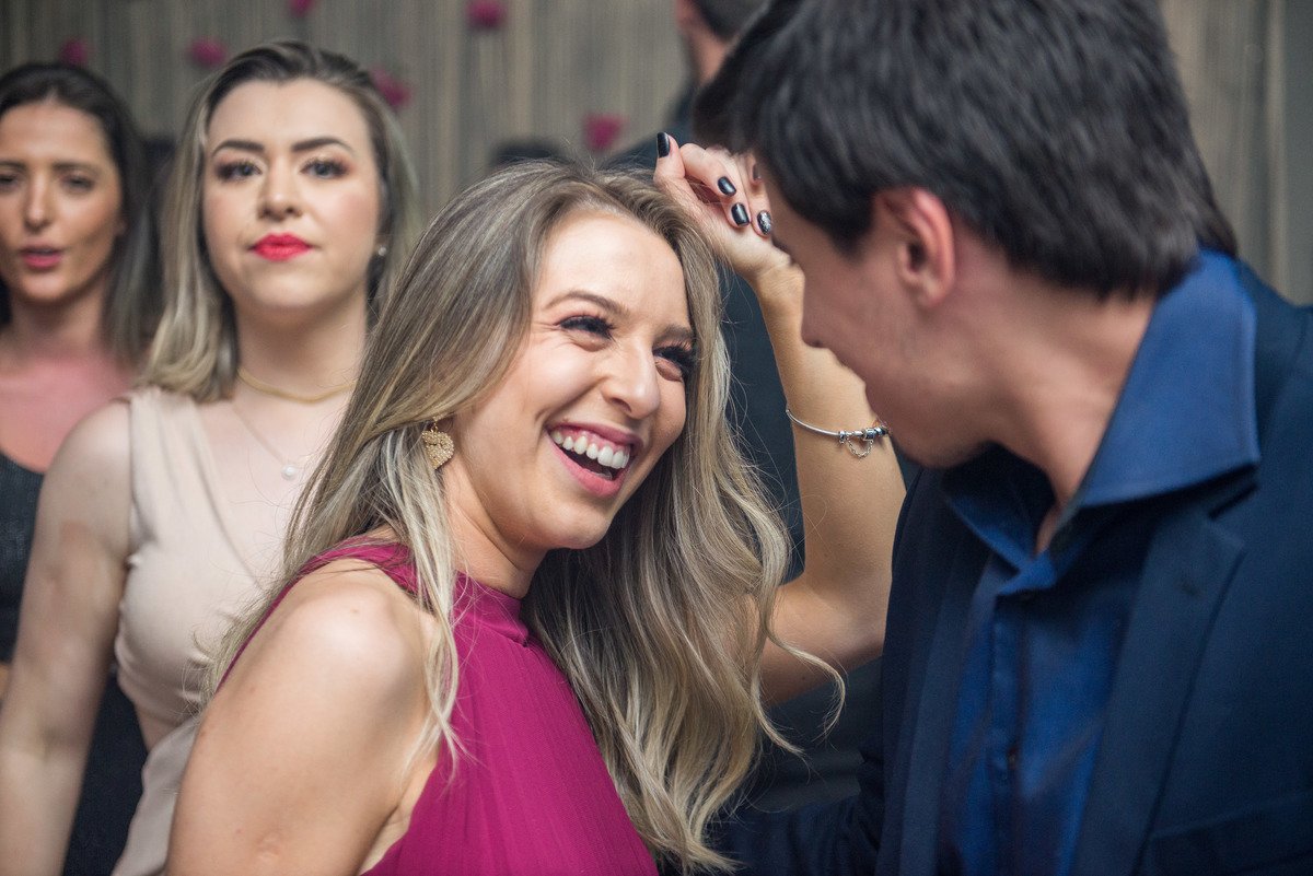Convidada da recepção dançando e sorrindo alegremente. Foto por Marco Moscarelli Fotografo Pelotas.