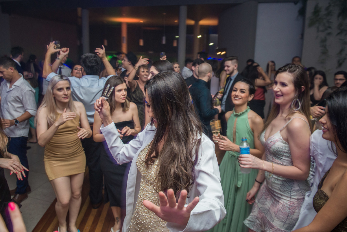 Formanda dançando feliz durante a festa de formatura. Foto por Marco Moscarelli Fotografo Pelotas.
