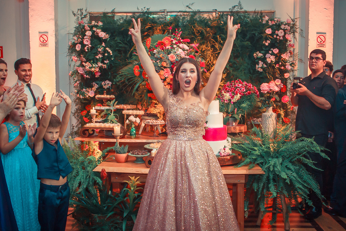 Debutante vibrando de alegria com os braços para o alto durante a sua em sua  festa de 15 anos em jaguarão. Foto por Marco Moscarelli  fotografo pelotas.