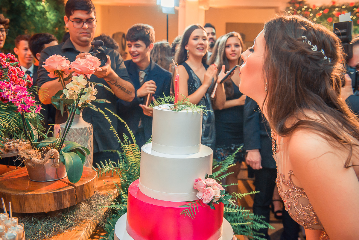Debutante apagando as velas do bolo de 15 anos logo após os parabéns em sua em sua  festa de 15 anos em jaguarão. Foto por Marco Moscarelli  fotografo pelotas. 
