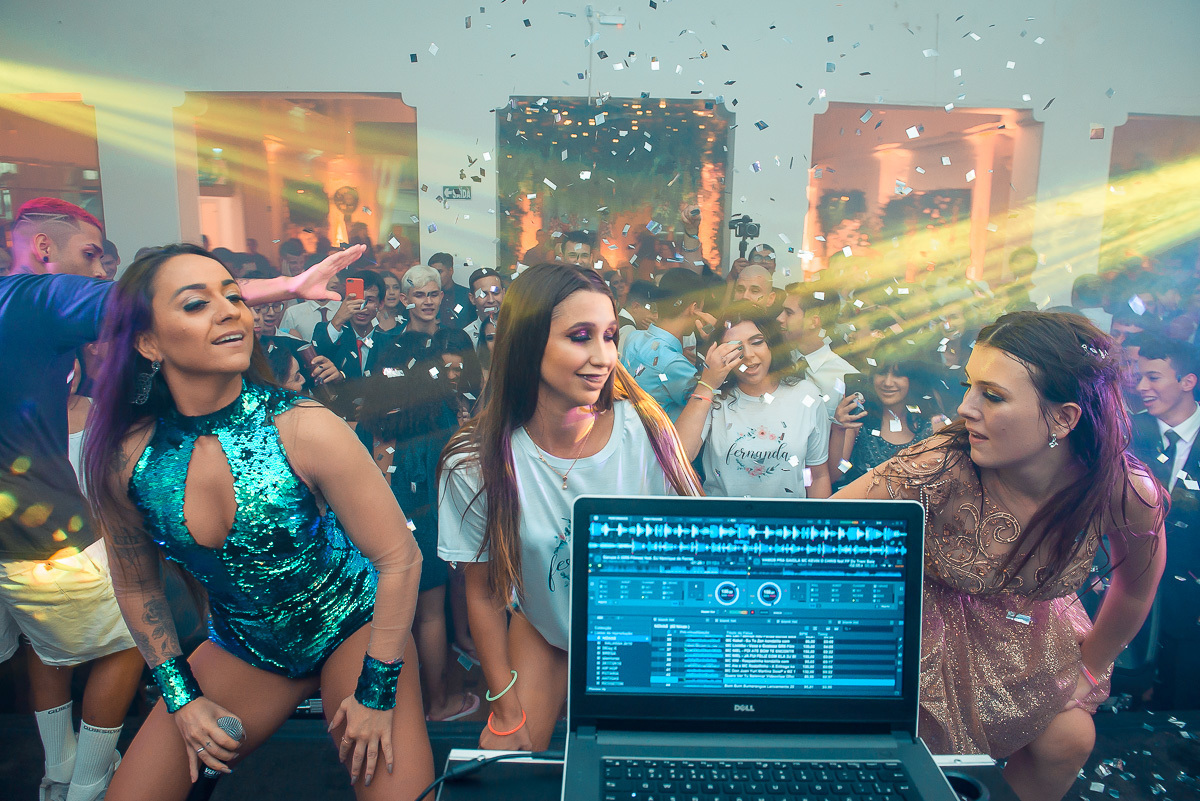 Debutante dançando com uma amiga e a DJ muito feliz em cima do palco durante a sua festa de 15 anos em jaguarão.  Foto por Marco Moscarelli fotografo Pelotas.