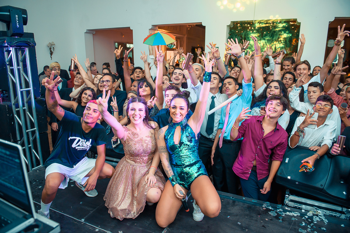 Debutante  muito feliz em cima do palco com seus amigos  durante a sua festa de 15 anos em jaguarão.  Foto por Marco Moscarelli fotografo Pelotas. 