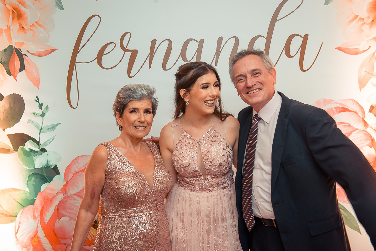 Debutante posando para fotos sorridente com seus pais antes da festa de 15 anos em jaguarão. Foto por Marco Moscarelli fotografo Pelotas.