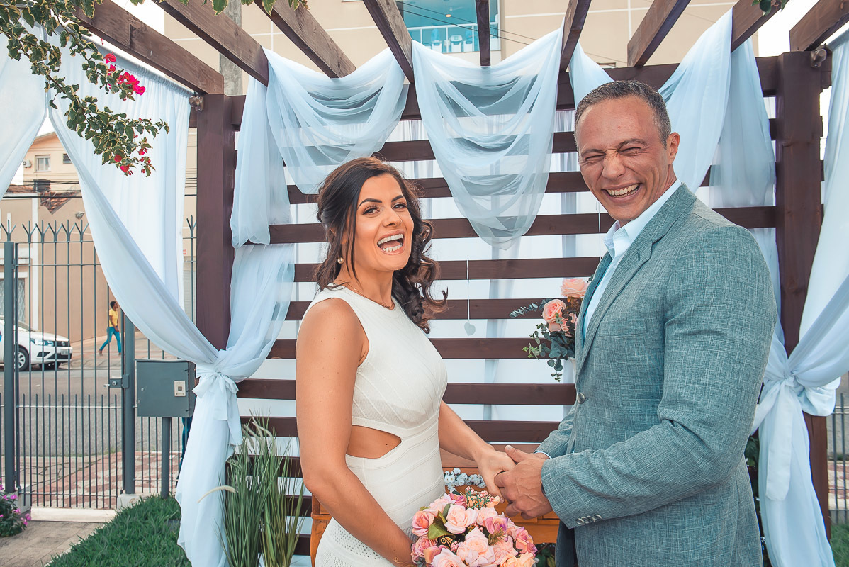 Noivos rindo muito durante a sua cerimônia de casamento. Retoques finais da maquiagem da noiva momentos antes do casamento. Foto por Marco Moscarelli Fotógrafo Pelotas.