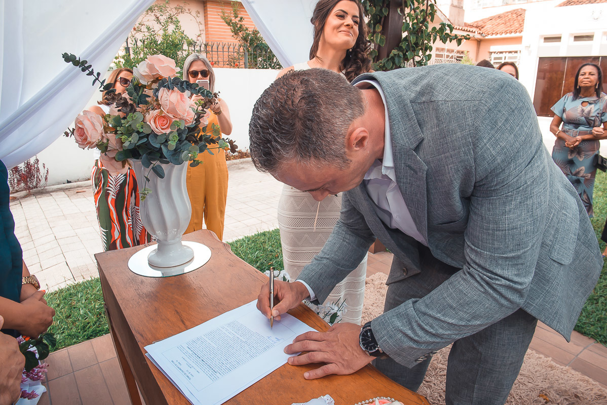 Noivo assinado a certidão de casamento logo após a cerimônia de casamento.  Foto por Marco Moscarelli Fotógrafo Pelotas