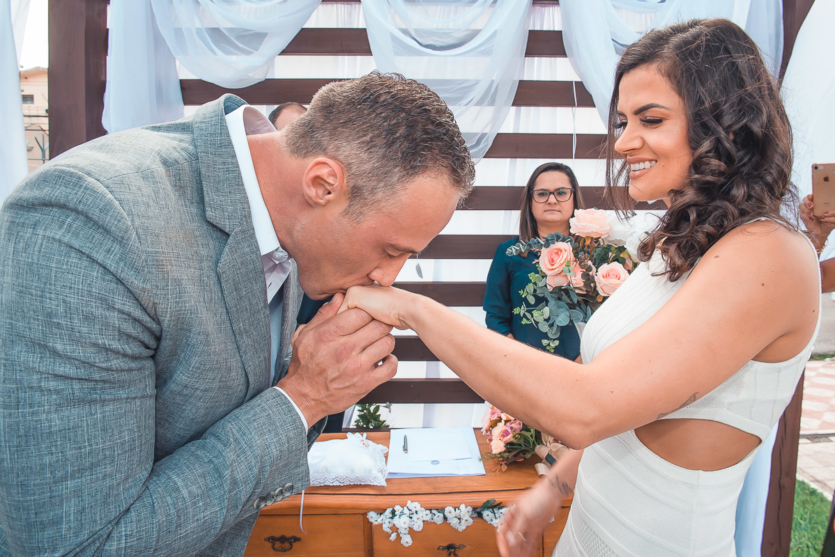 Lindo momento do noivo beijando a mão da noiva durante o casamento.  Foto por Marco Moscarelli Fotógrafo Pelotas