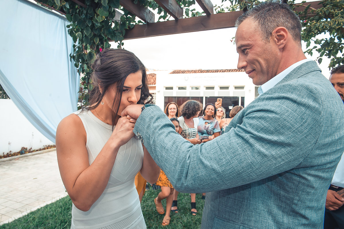 Noiva dando um lindo beijo na mão do noivo durante o casamento.  Foto por Marco Moscarelli Fotógrafo Pelotas