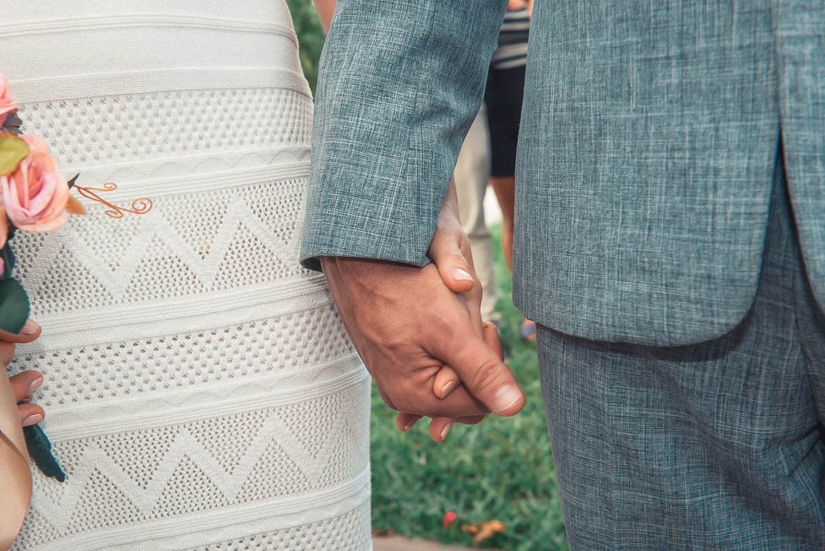 Fotografia em detalhe das mãos dadas dos noivos durante o casamento.  Foto por Marco Moscarelli Fotógrafo Pelotas