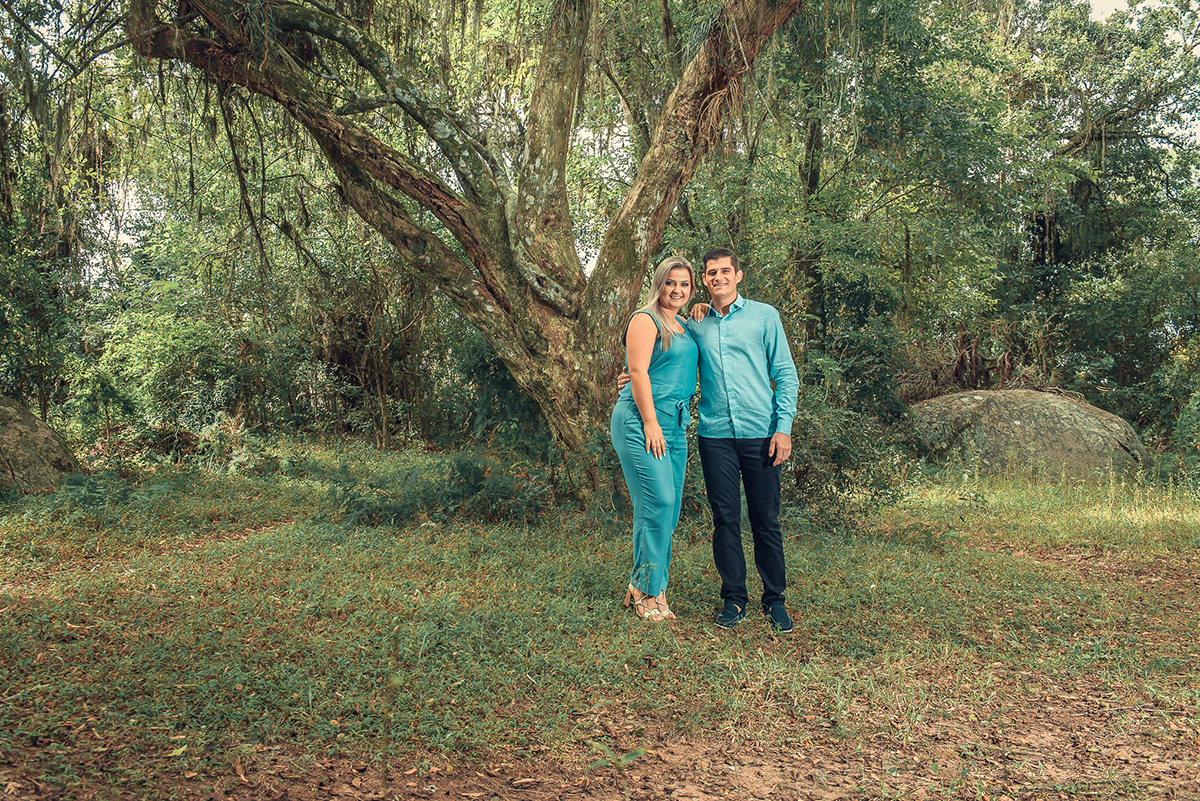 Casal de noivos posando ao pé de uma figueira durante o seu ensaio pré wedding antes do seu casamento. Foto por Marco Moscarelli Fotógrafo Pelotas.