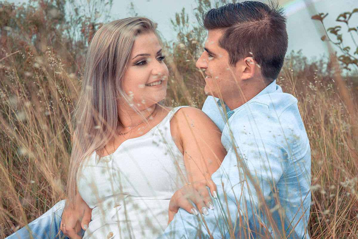 Casal de noivos trocando olhares em um campo de trigo durante seu ensaio pré-wedding. ensaio de casal. Noivos trocando um belo beijo durante o seu ensaio de casal. Foto por Marco Moscarelli Fotógrafo Pelotas.