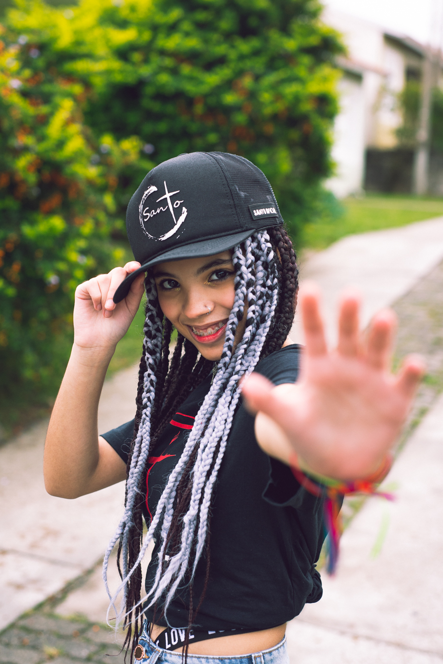 Modelo posando com boné  preto e jeans durante tendo sentada na rua verdes  seu ensaio fotográfico Tumblr em Pelotas. Foto por Marco Moscarelli Fotógrafo Pelotas.