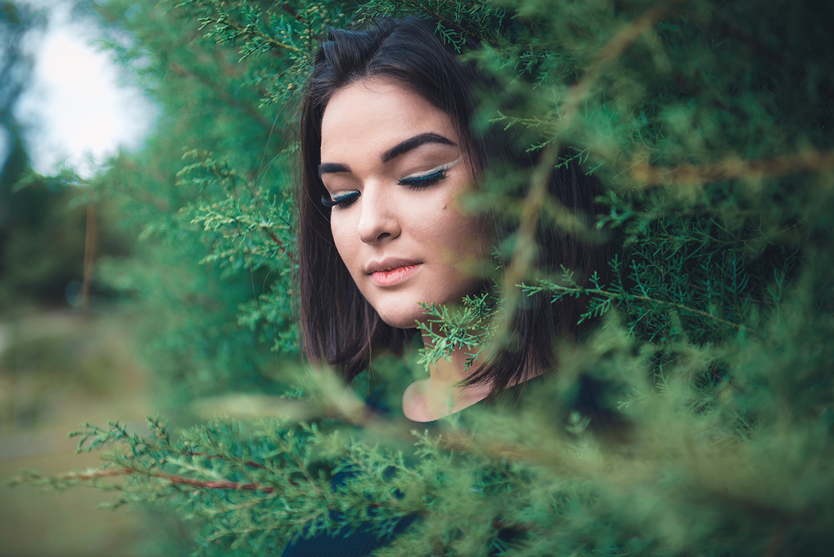 Linda fotografia em detalhe da modelo em meio a folhagens de arvore. Foto por Marco Moscarelli Fotógrafo Pelotas.