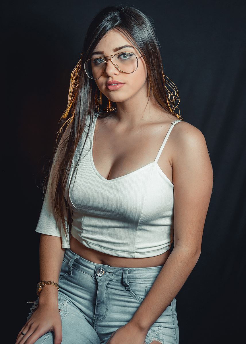 Modelo posando para fotos em estúdio fotográfico com fundo preto  durante editorial de moda. Foto por Marco Moscarelli Fotógrafo Pelotas.