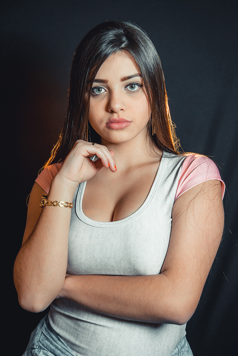 Modelo posando para fotos em estúdio fotográfico com fundo preto  durante editorial de moda. Foto por Marco Moscarelli Fotógrafo Pelotas.