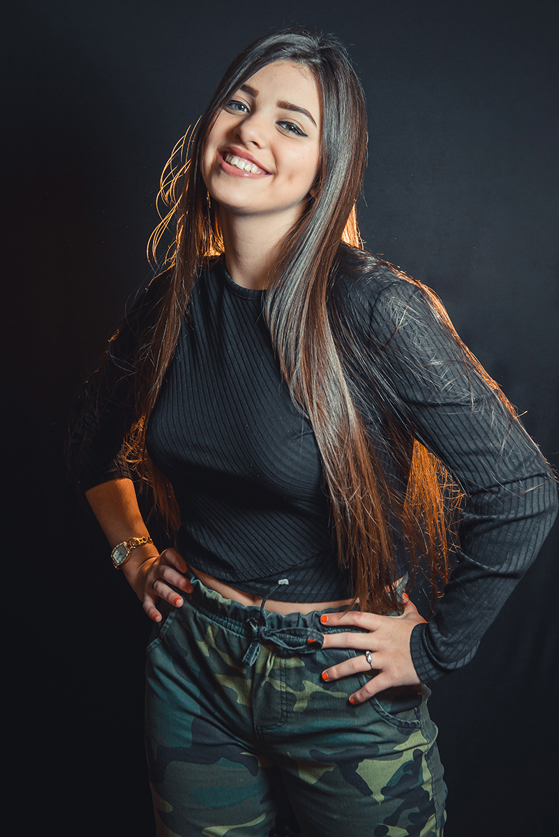 Modelo posando para fotos em estúdio fotográfico com fundo preto  durante editorial de moda. Foto por Marco Moscarelli Fotógrafo Pelotas.