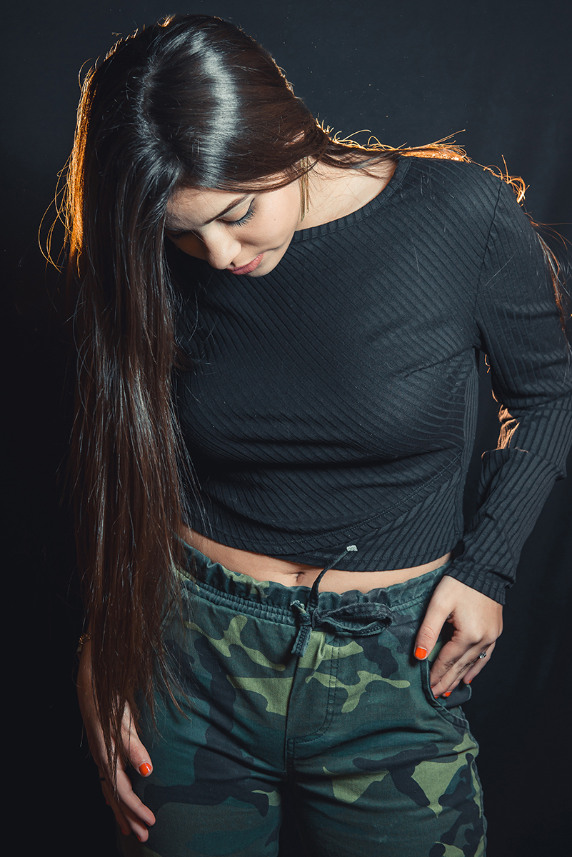 Modelo posando para fotos em estúdio fotográfico com fundo preto  durante editorial de moda. Foto por Marco Moscarelli Fotógrafo Pelotas.