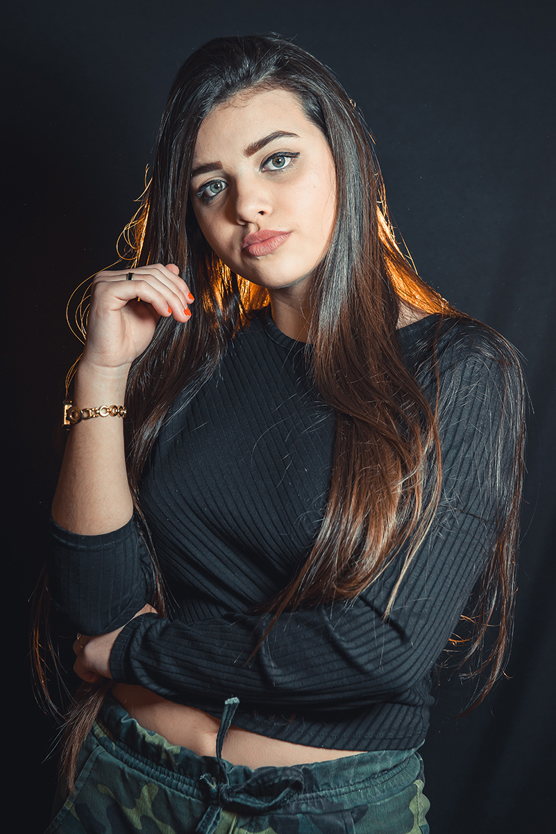 Modelo posando para fotos em estúdio fotográfico com fundo preto  durante editorial de moda. Foto por Marco Moscarelli Fotógrafo Pelotas.