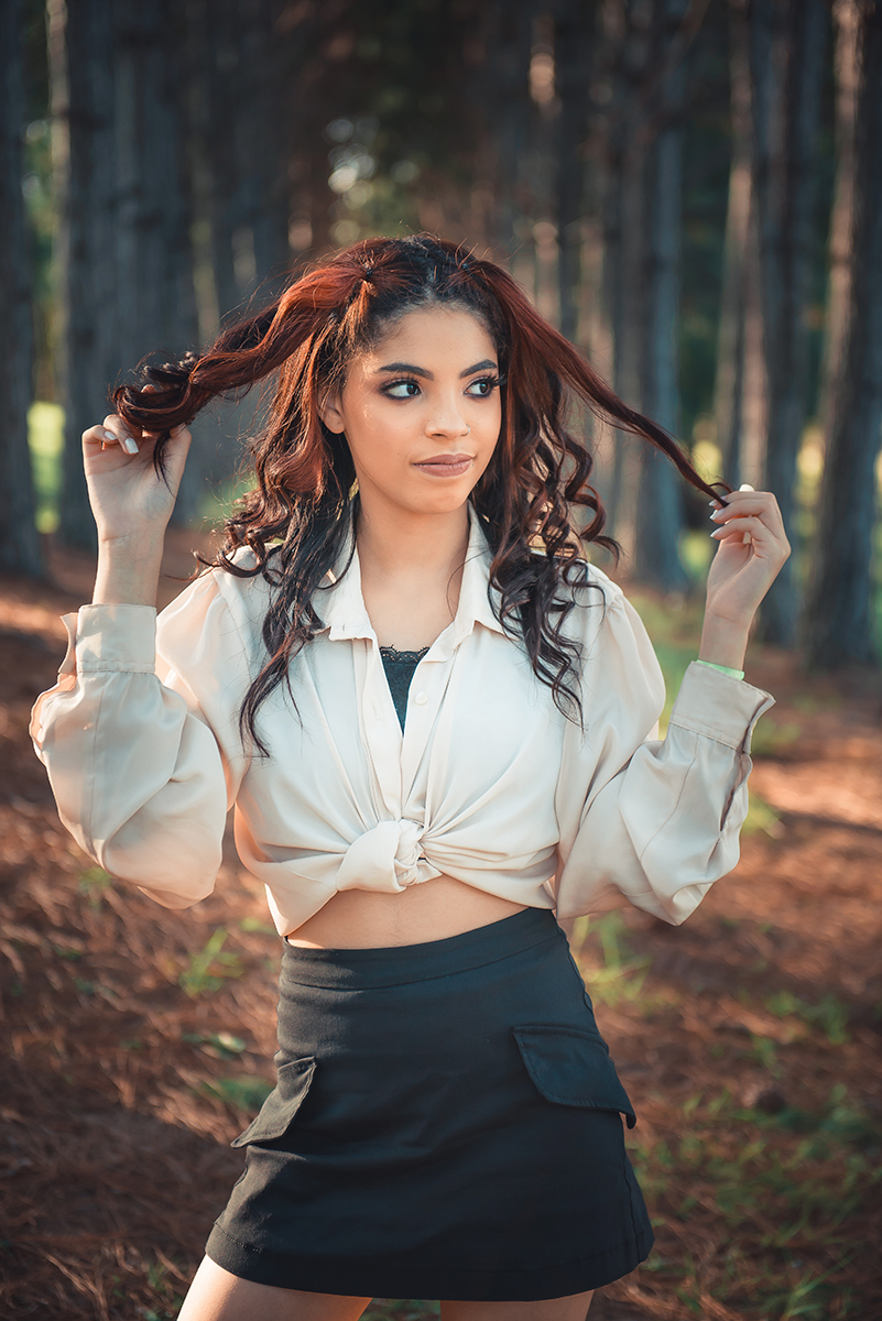 Debutante posando para foto brincando com o cabelo durante seu ensaio fotográfico de 15 anos. Foto por Marco Moscarelli Fotógrafo Pelotas. 
