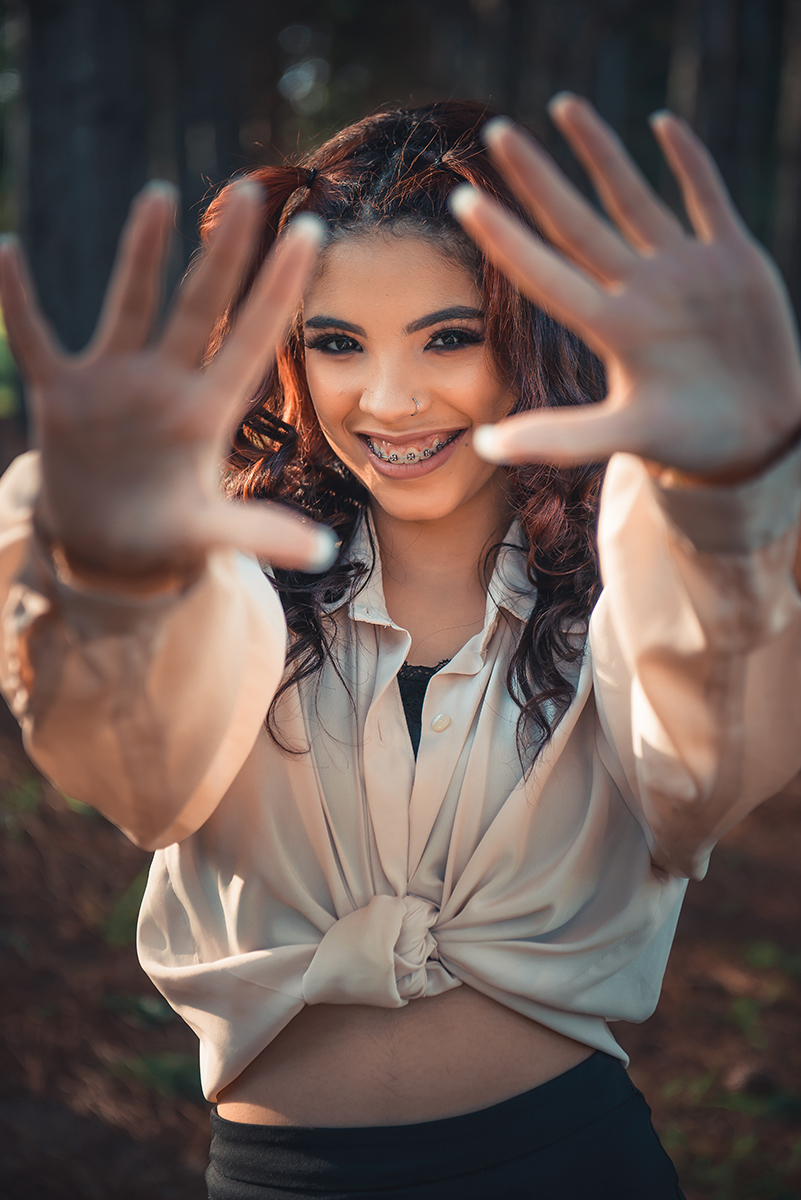 Debutante fotografada esticando as mãos para a camera durante  seu ensaio fotográfico de 15 anos.Foto por Marco Moscarelli Fotógrafo Pelotas. 