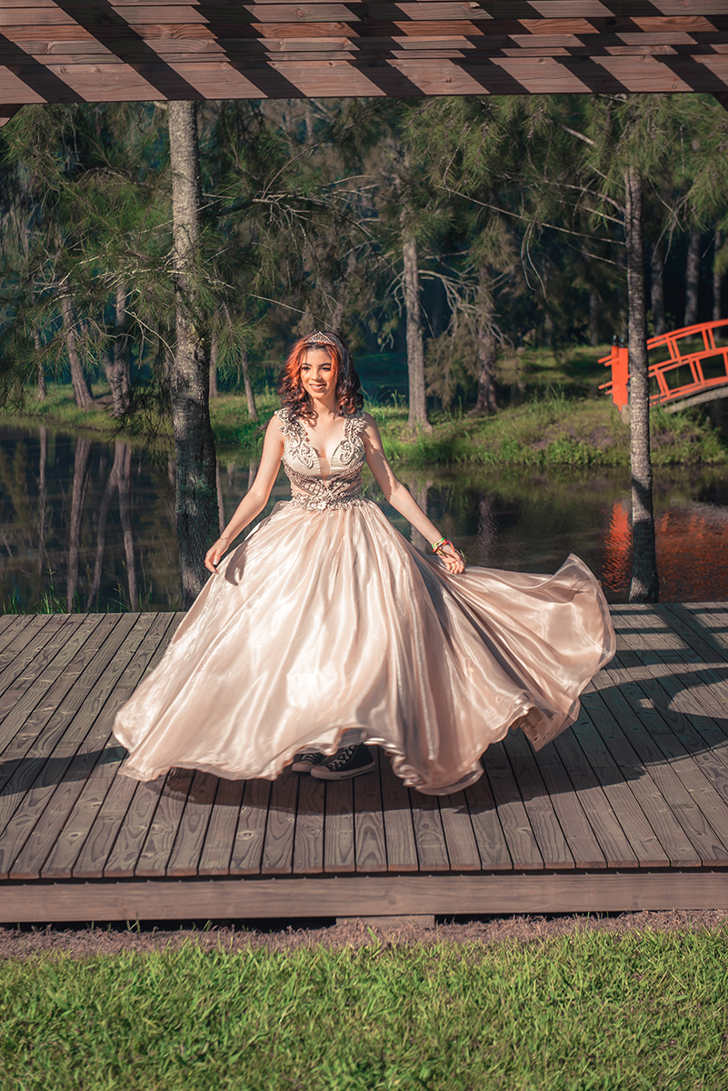 com seu vestido de 15 anos durante seu ensaio fotográfico de 15 anos, Debutante caminhando e olhando para trás em um lindo retrato durante seu ensaio fotográfico de 15 anos. Foto por Marco Moscarelli Fotógrafo Pelotas. 
