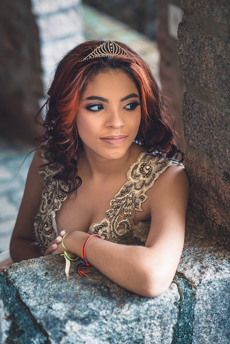 Debutante fotografada sorrindo alegre em uma janela de pedra de castelo durante seu ensaio fotográfico de 15 anos.  Foto por Marco Moscarelli 