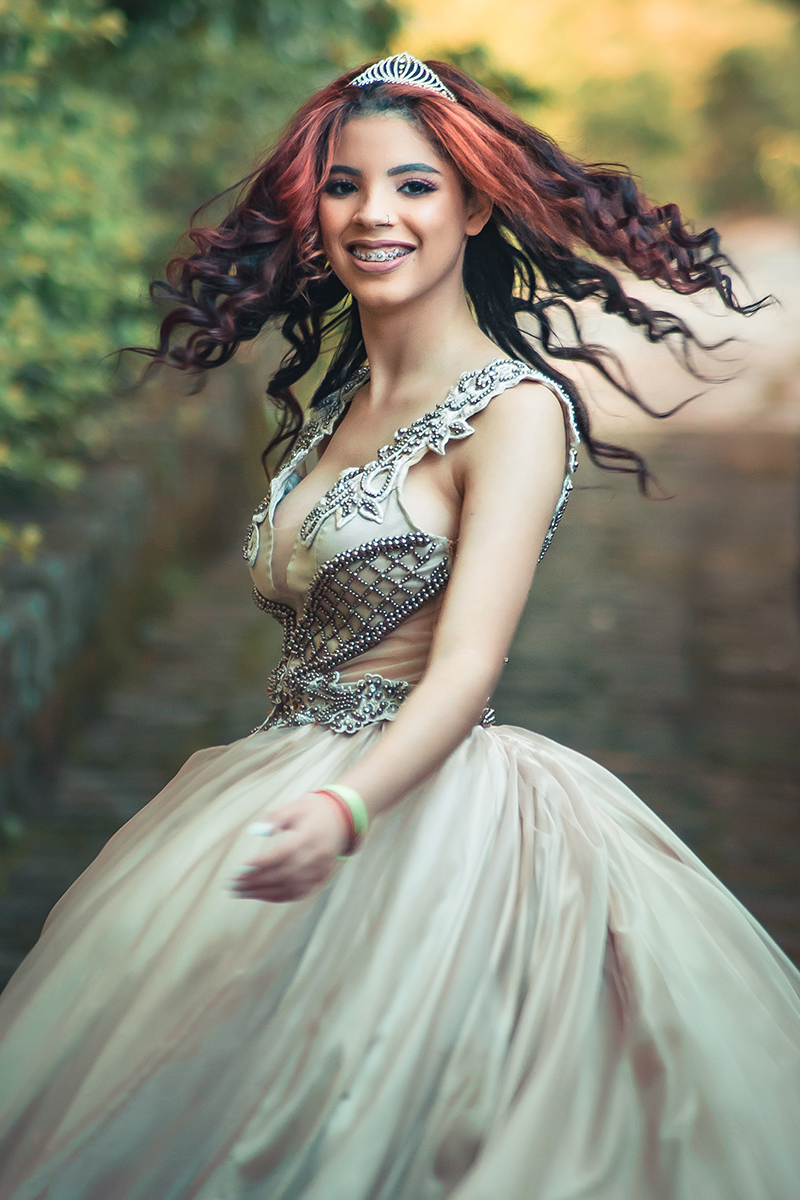 Debutante caminhando e olhando para trás em um lindo retrato durante seu ensaio fotográfico de 15 anos. Foto por Marco Moscarelli Fotógrafo Pelotas.  