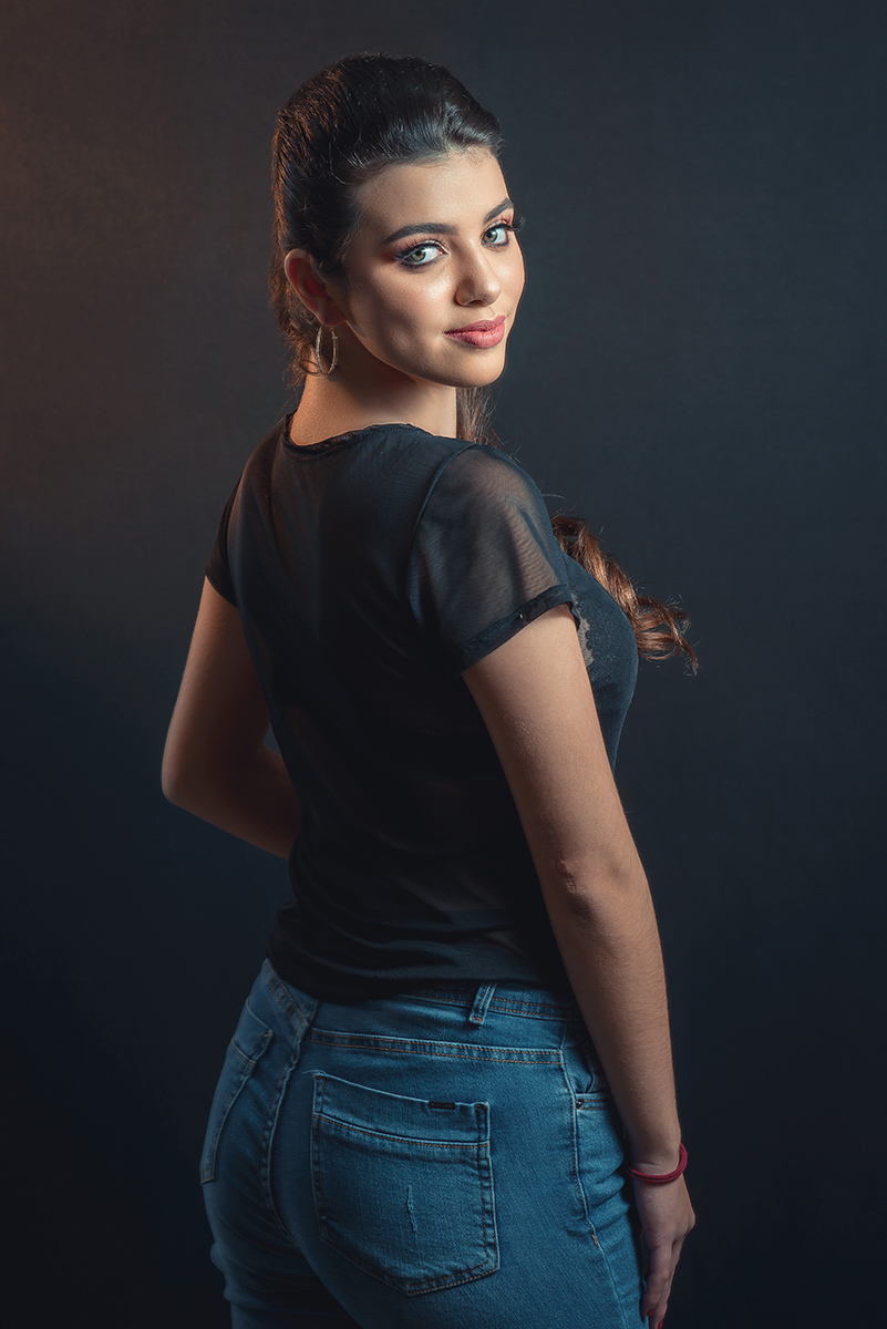 Modelo posando em estúdio com fundo preto usando uma blusa preta transparente e calça jeans. Olhos verdes chamando atenção neste lindo editorial de moda em estúdio fotográfico. Foto por Marco Moscarelli Fotógrafo Pelotas.